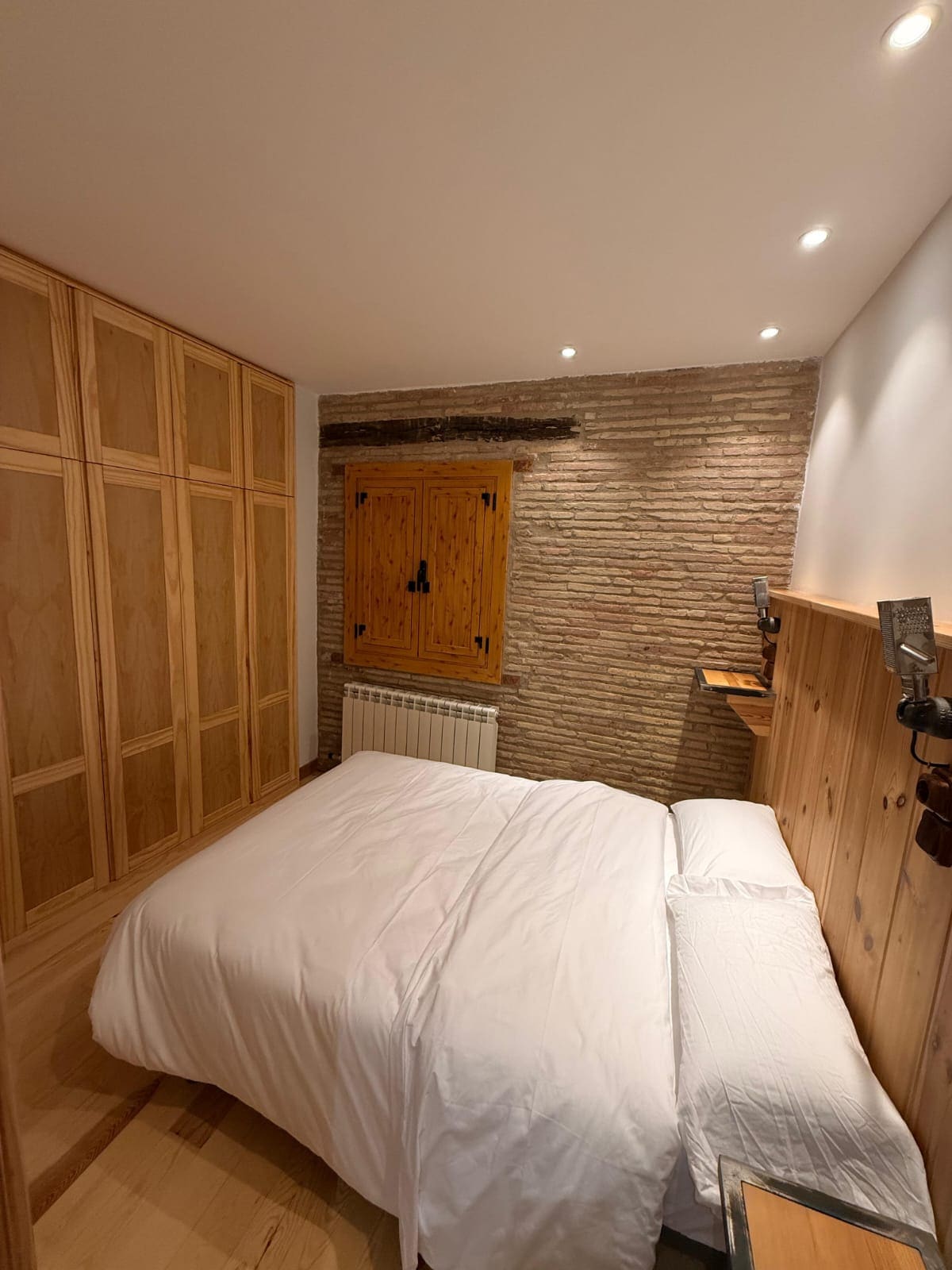 Dormitorio con armario de madera de pino a medida en una vivienda reformada