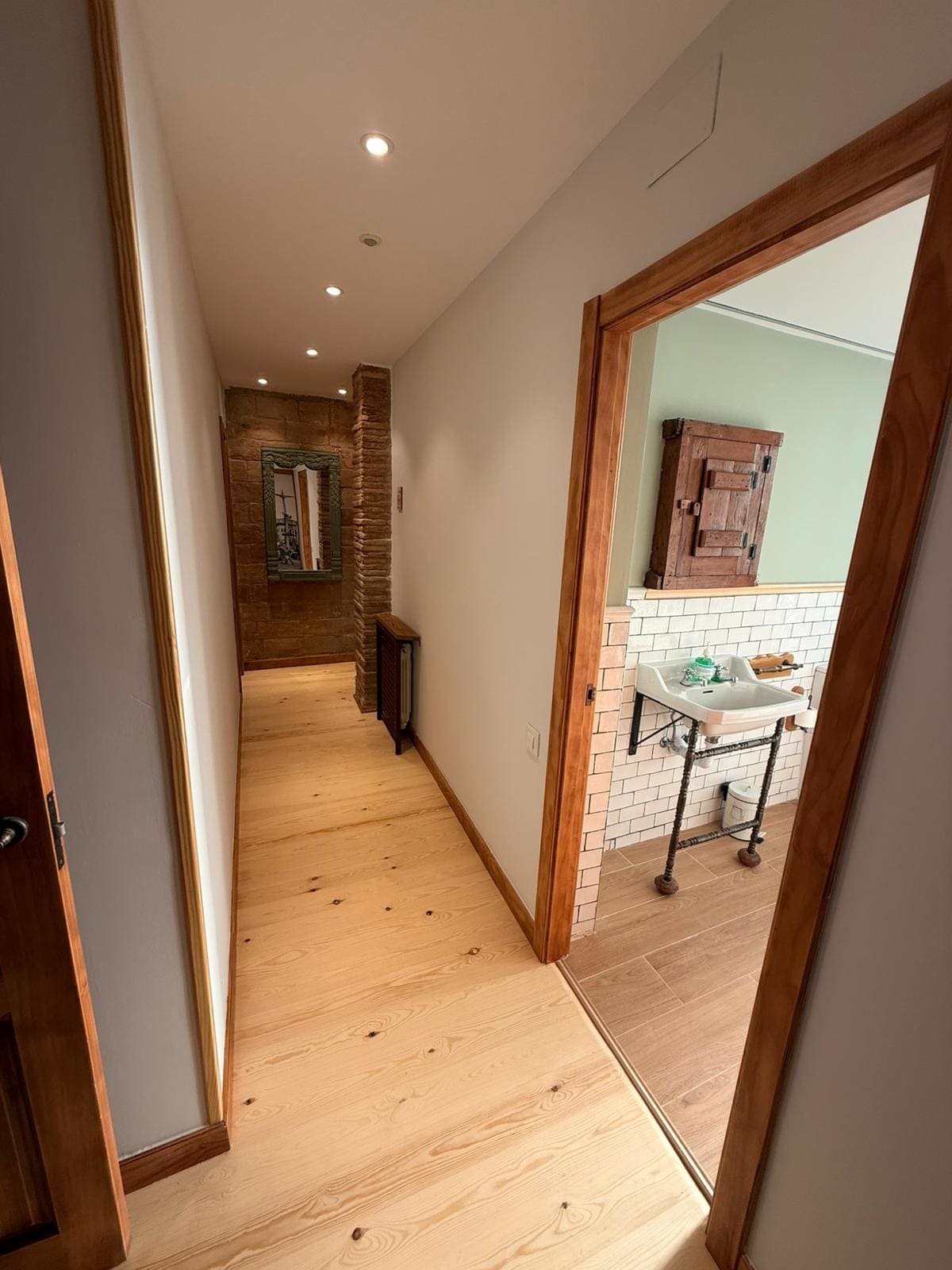 Pasillo interior reformado junto a un baño con azulejo de estilo vintage