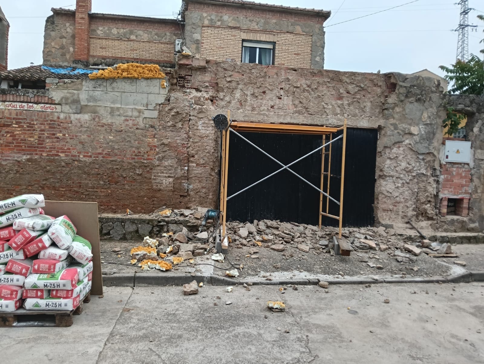 Fachada antigua con el revoco desprendido y manchas de humedad antes de la obra