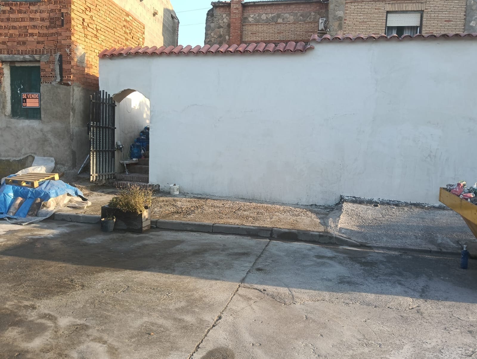 El mismo muro terminado por JIMA, pintado en blanco y rematado con teja